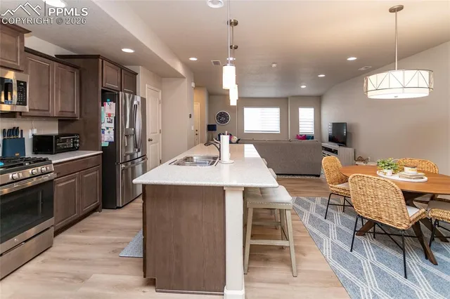 a large kitchen with kitchen island a sink table and chairs