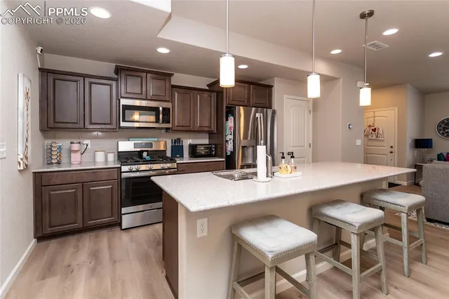 a kitchen with stainless steel appliances kitchen island granite countertop a sink and cabinets