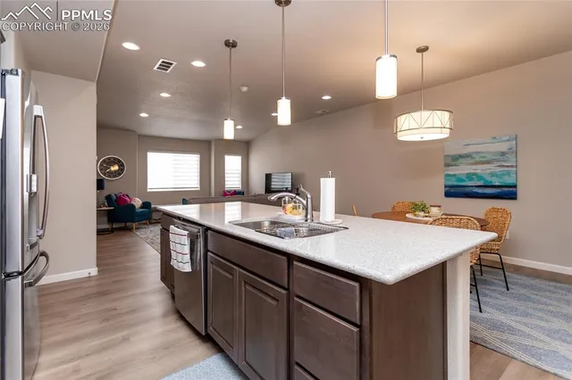 a kitchen with a sink chandelier and living room view