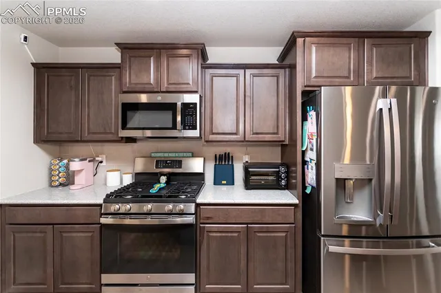 a kitchen with cabinets stainless steel appliances and a counter space