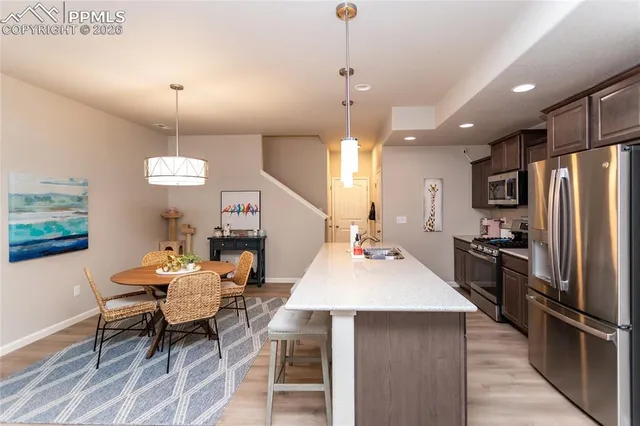 a kitchen with a table chairs refrigerator and microwave