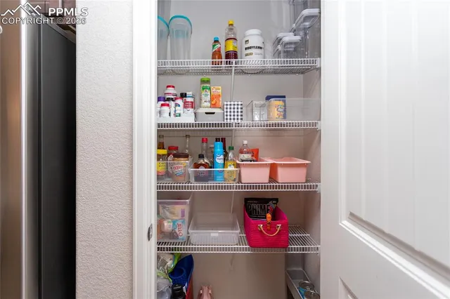 a utility room with stainless steel appliances and shelf