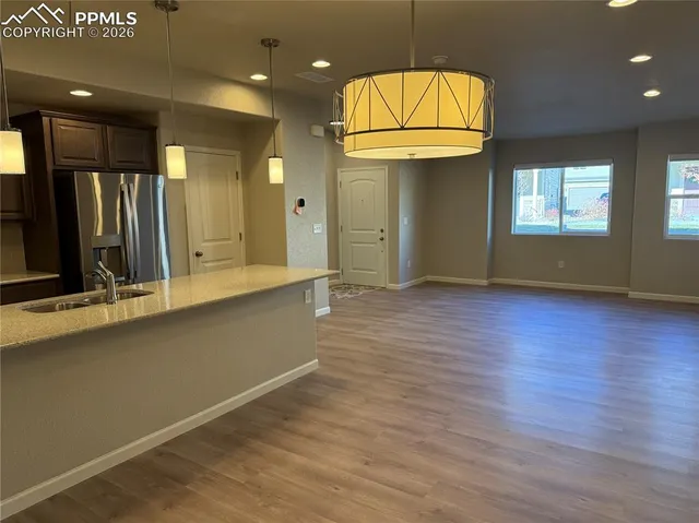 an empty room with wooden floor and cabinet