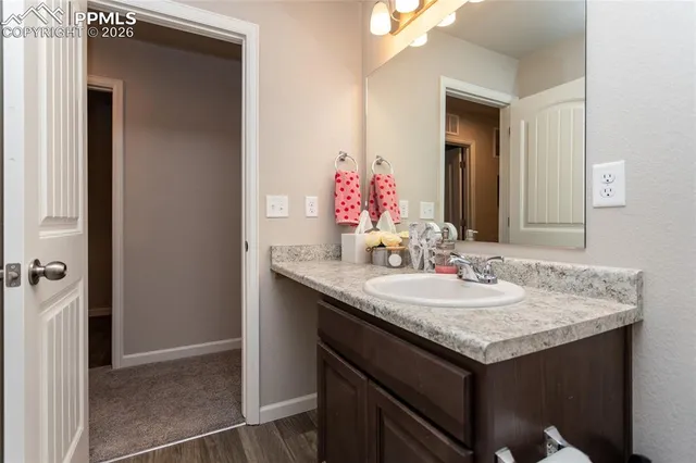 a bathroom with a granite countertop sink and a mirror