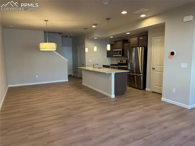 a view of kitchen with stainless steel appliances granite countertop a stove and a refrigerator