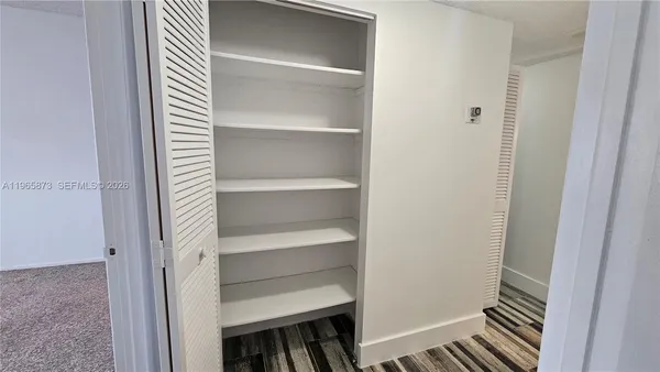 a view of walk in closet with empty racks