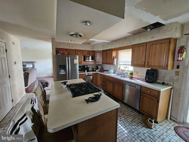 a kitchen with stainless steel appliances a stove a sink dishwasher a refrigerator a sink and cabinets