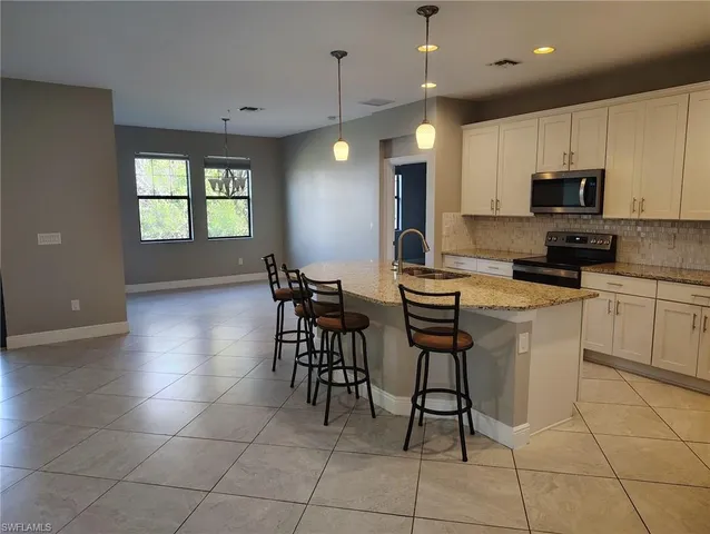 a kitchen with stainless steel appliances granite countertop a stove a sink a microwave and a refrigerator