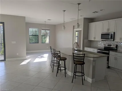 a kitchen with stainless steel appliances a stove a sink refrigerator and a microwave