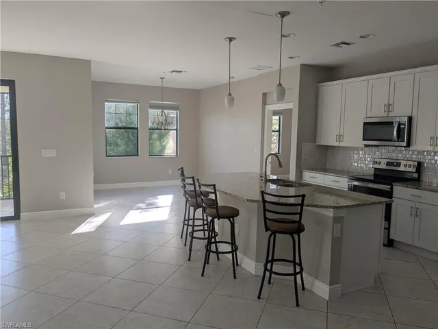 a kitchen with stainless steel appliances a stove a sink refrigerator and a microwave