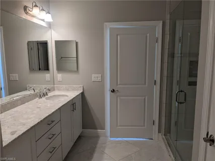 a bathroom with a granite countertop sink and a mirror