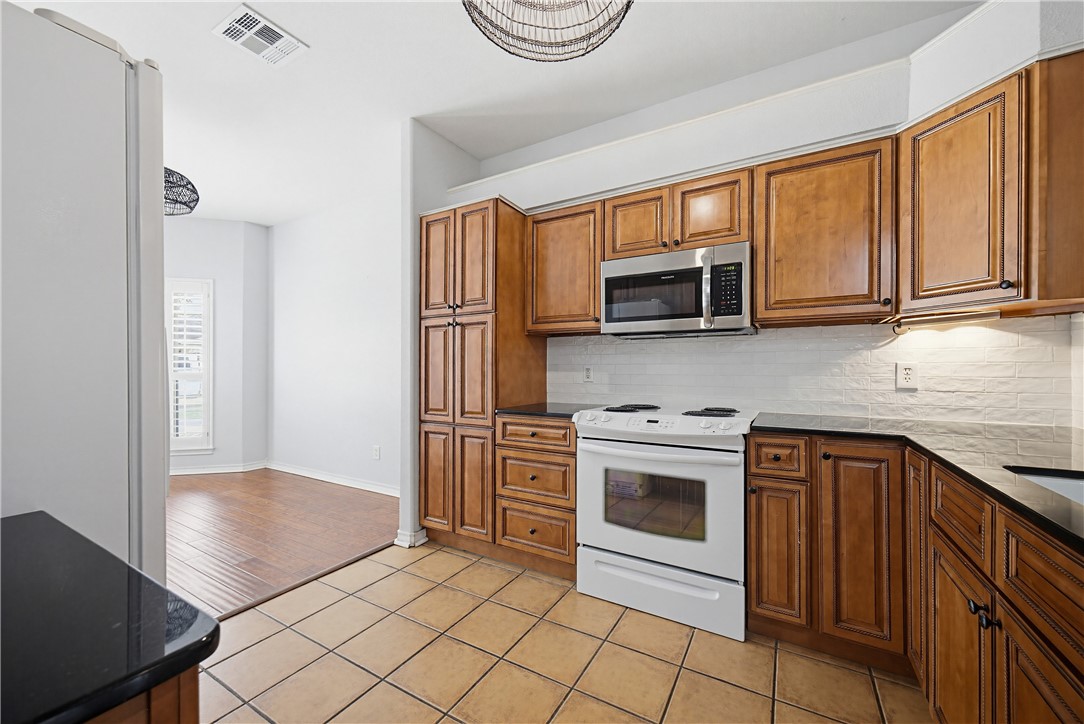 7251 Prairie Drive, Unit 6 Corpus Christi, TX 78413 - Photo 10 of 28 a kitchen with stainless steel appliances granite countertop a stove a sink and a refrigerator