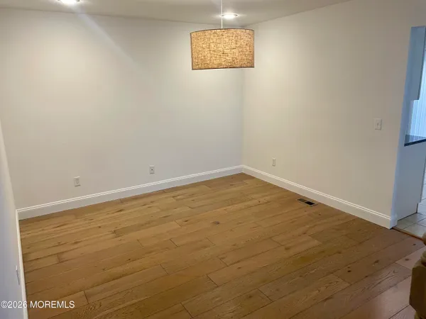 an empty room with a wooden floor and window
