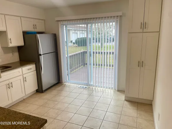 a view of a kitchen with refrigerator and cabinet