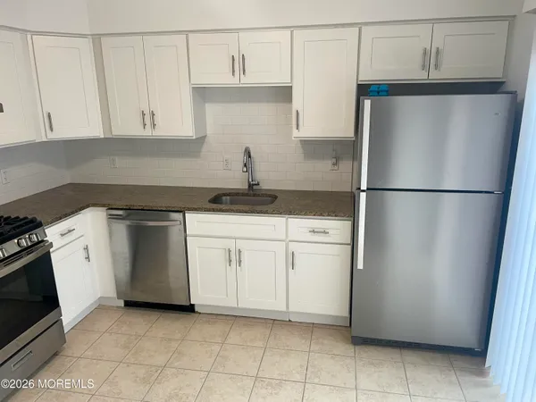 a kitchen with a refrigerator sink stove and cabinets