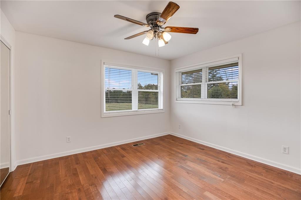 6792 Rockmart Road Southeast Silver Creek, GA 30173 - Photo 25 of 43 a view of an empty room with wooden floor and a chandelier fan