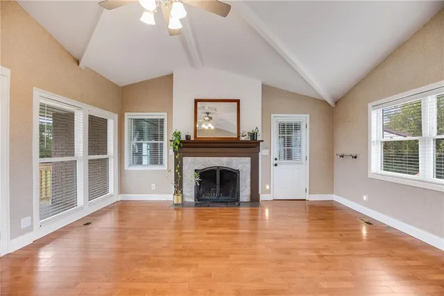 a view of a livingroom with a fireplace window and wooden floor