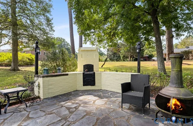 a view of a patio with a dining table and chairs with a fire pit