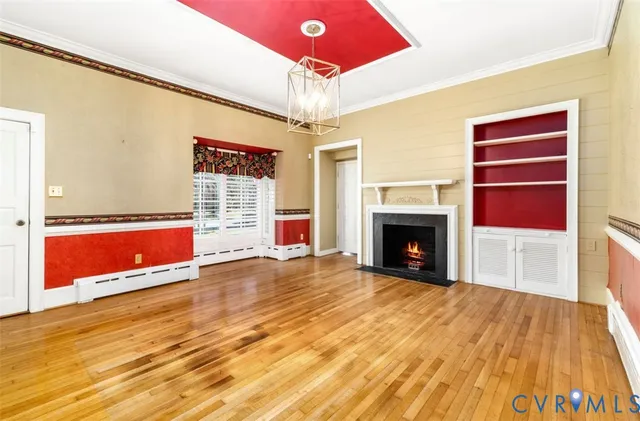 a view of an empty room with window fireplace and chandelier