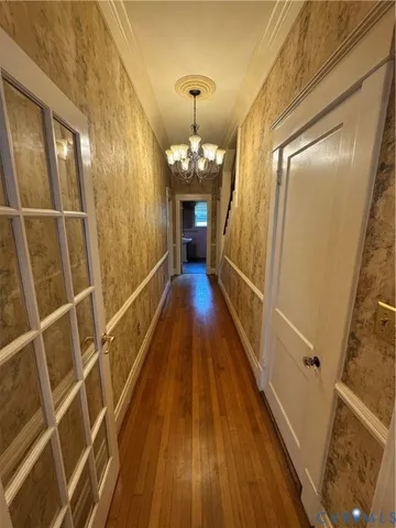 a view of a hallway with wooden floor and staircase
