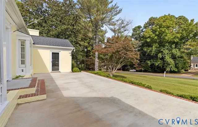 a house with yard and a trees in front of it