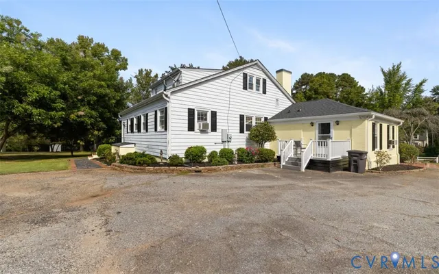 a view of a house with a yard and potted plants