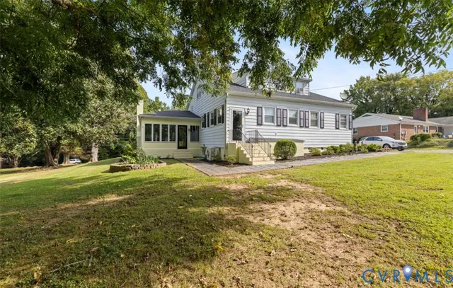 a front view of a house with a garden and trees