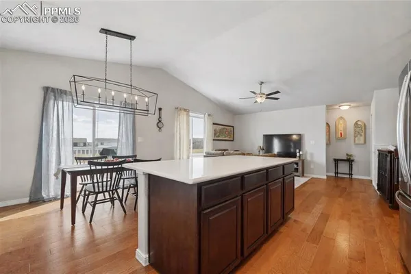 a kitchen with kitchen island granite countertop a sink a counter top space and stainless steel appliances