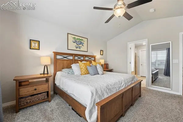 a bedroom with bed and paintings on the wall