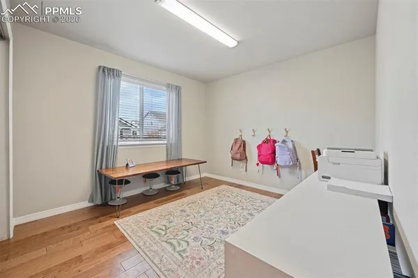 a living room with a couch and dresser with wooden floor
