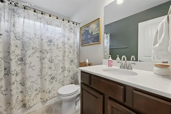 a bathroom with a granite countertop sink toilet and a mirror