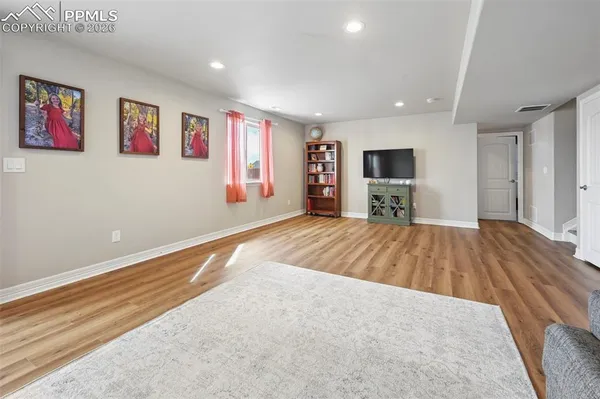 a large bedroom with a bed and wooden floor