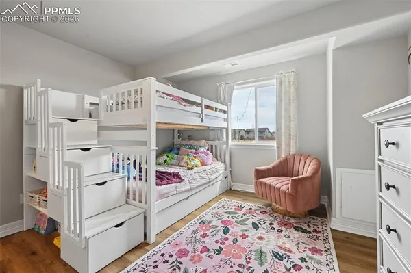a view of a bedroom with baby crib and lounge chair