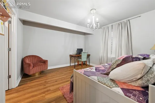 a bedroom with a bed and closet with wooden floor