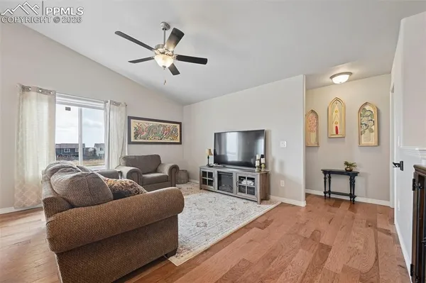 a living room with furniture a ceiling fan and a flat screen tv