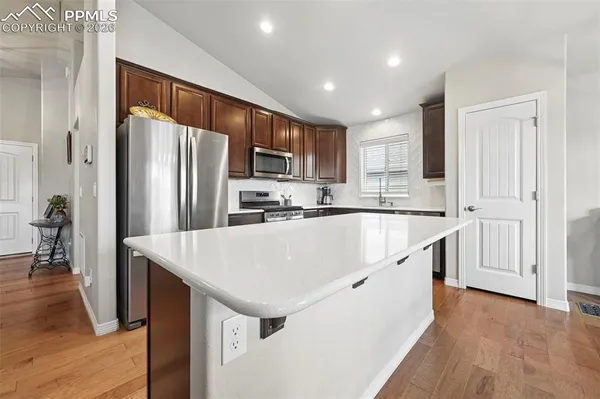 a kitchen with stainless steel appliances granite countertop a refrigerator a sink and a stove