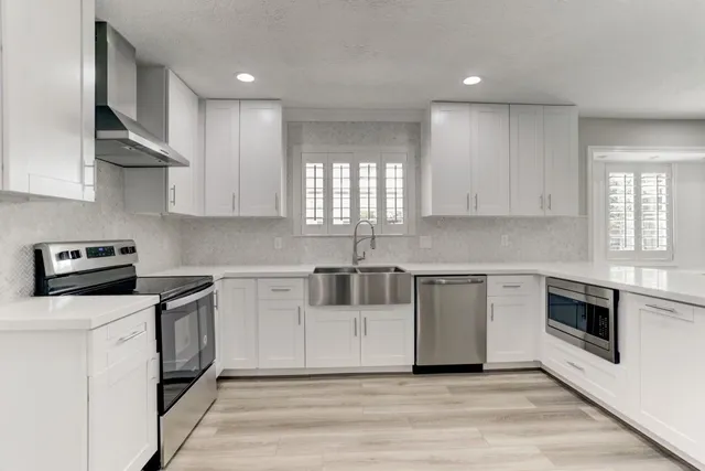 a kitchen with stainless steel appliances granite countertop a sink and a stove top oven