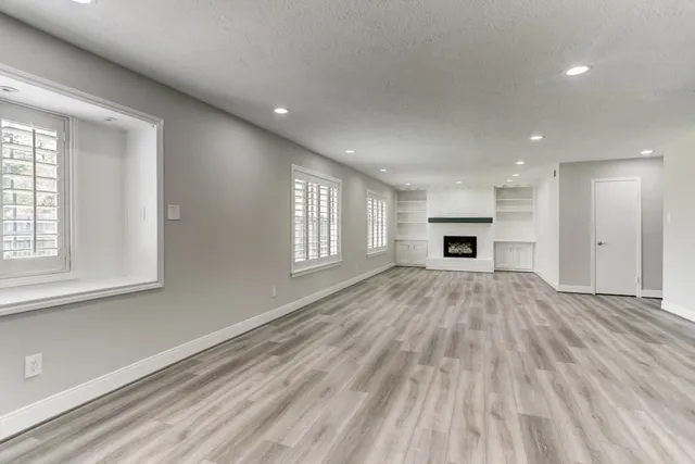 a view of empty room with a fireplace and window