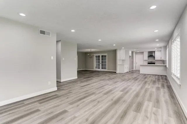 a view of a big room with wooden floor and windows