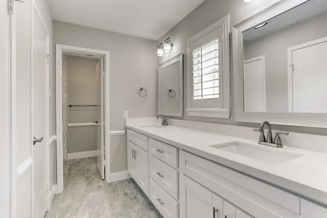 a bathroom with a double vanity sink and mirror
