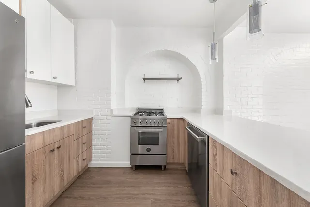 a kitchen with stainless steel appliances white cabinets and a sink