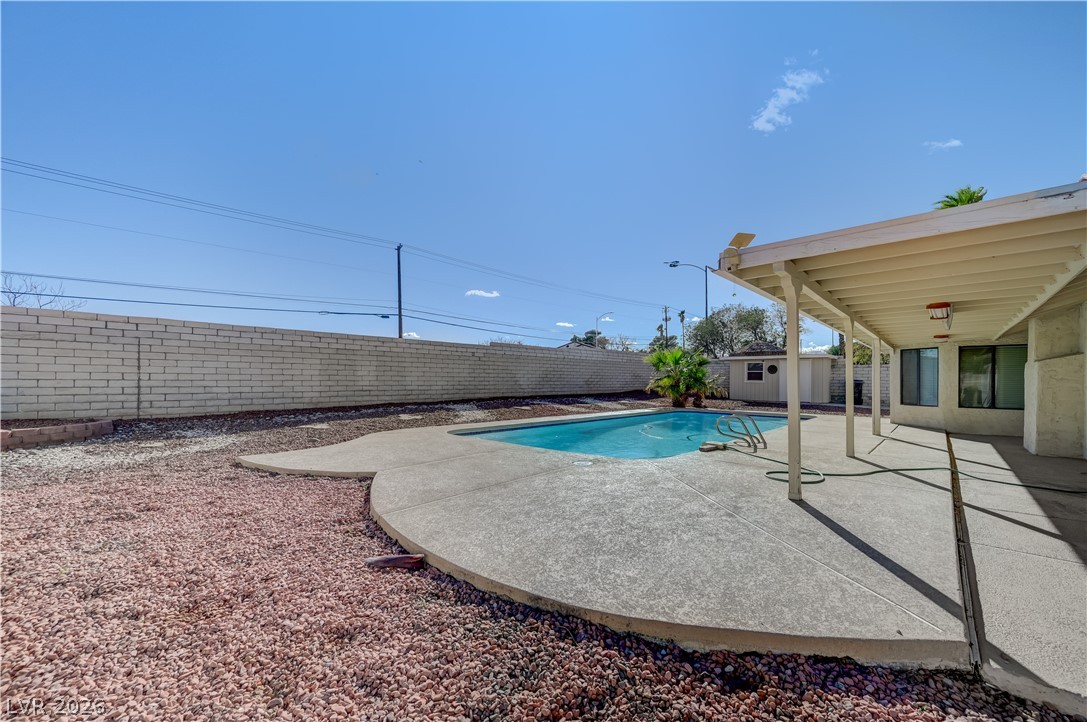 6635 Costa Brava Road Las Vegas, NV 89146 - Photo 52 of 59 A tranquil backyard oasis features a glistening swimming pool and a covered patio, perfect for relaxing.