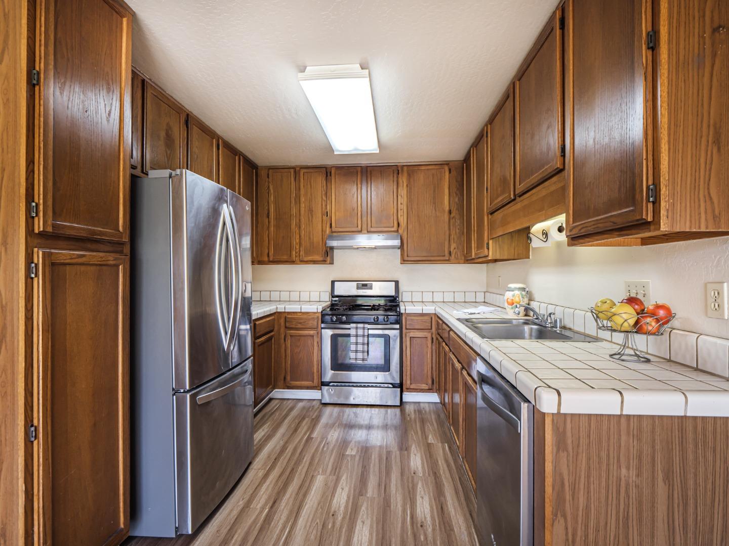 216 Silver Leaf Drive, Unit C Watsonville, CA 95076 - Photo 11 of 36 a kitchen with granite countertop stainless steel appliances a refrigerator a stove top oven and cabinets