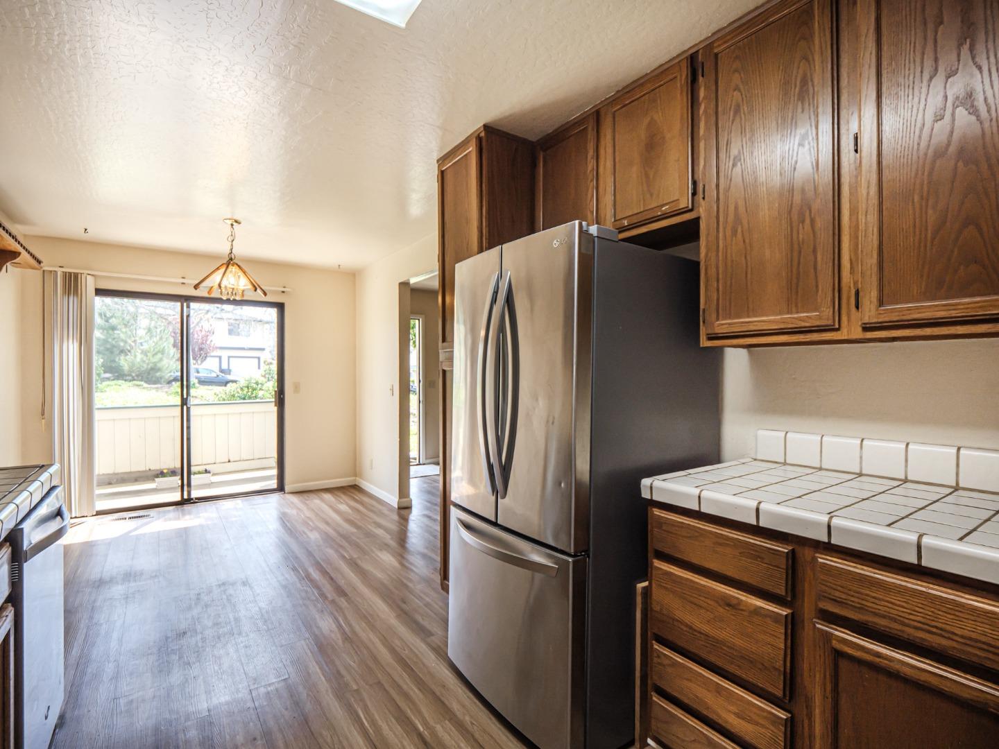 216 Silver Leaf Drive, Unit C Watsonville, CA 95076 - Photo 12 of 36 a kitchen with metallic refrigerator and wooden floor