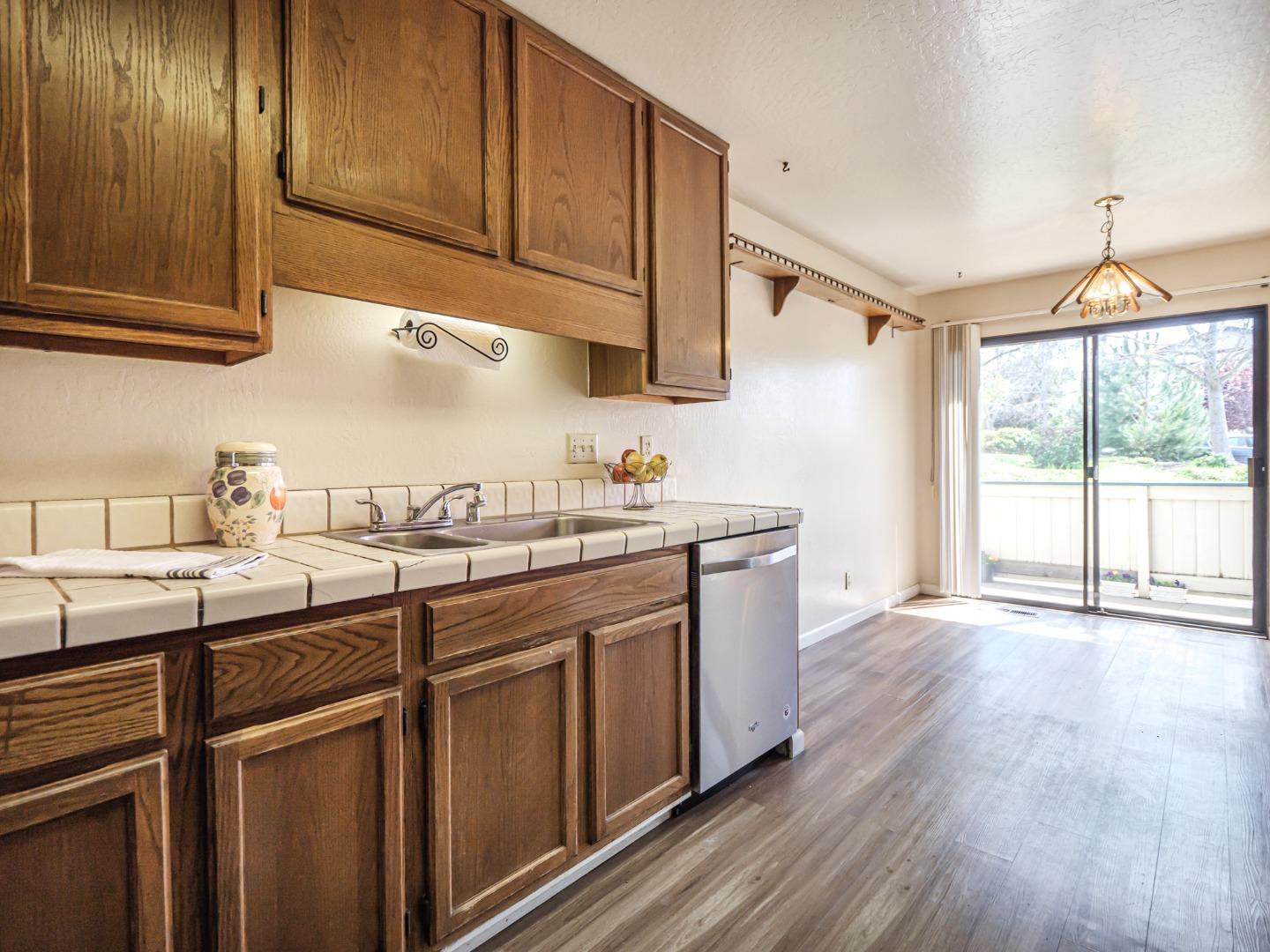 216 Silver Leaf Drive, Unit C Watsonville, CA 95076 - Photo 13 of 36 a kitchen with stainless steel appliances granite countertop wooden cabinets a sink and dishwasher with wooden floor