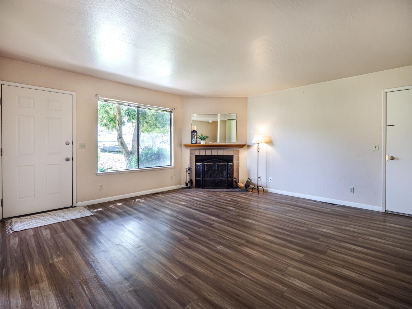 216 Silver Leaf Drive, Unit C Watsonville, CA 95076 - Photo 5 of 36 an empty room with wooden floor fireplace and windows