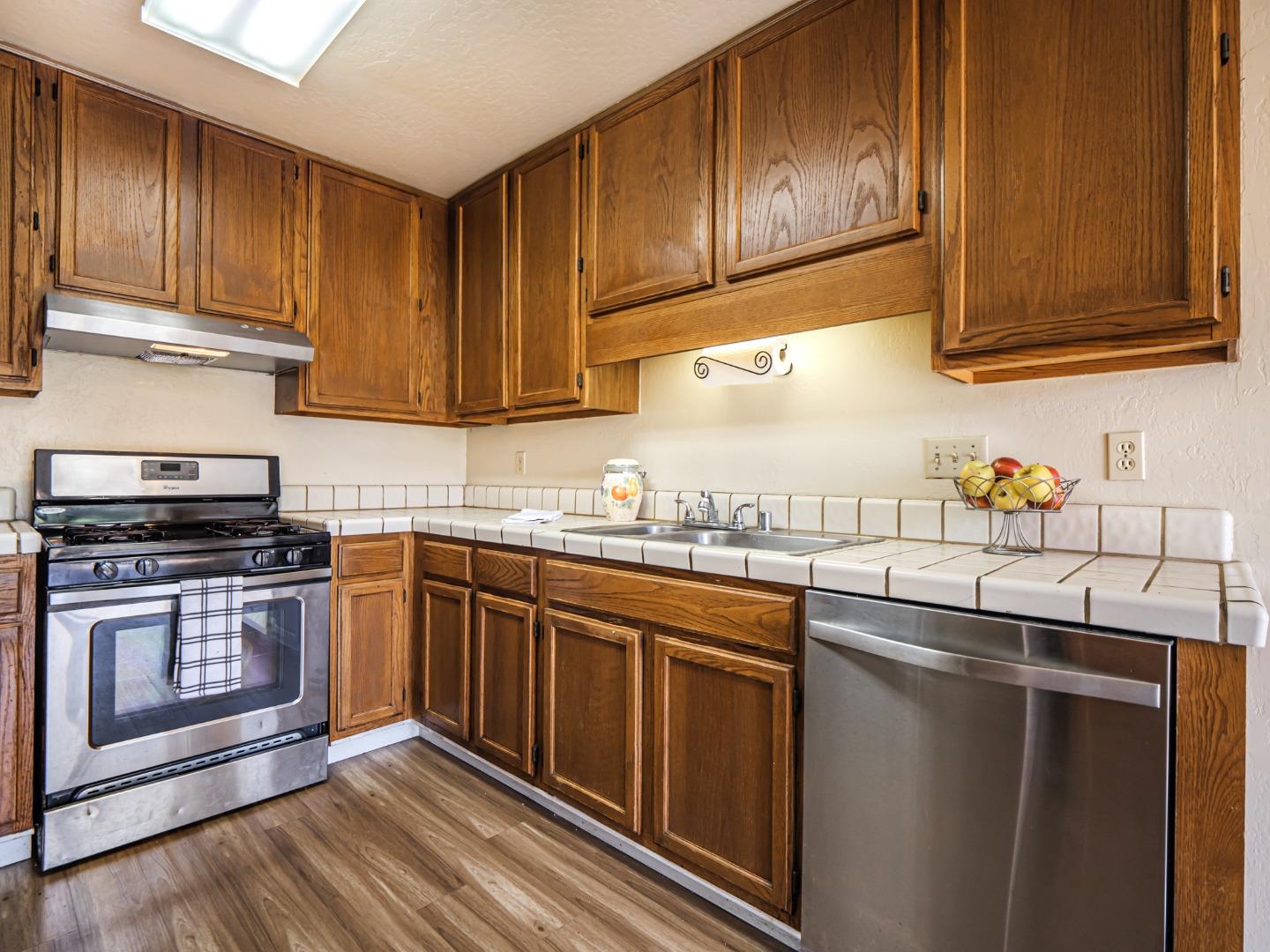 216 Silver Leaf Drive, Unit C Watsonville, CA 95076 - Photo 10 of 36 a kitchen with granite countertop wood cabinets stainless steel appliances and a sink
