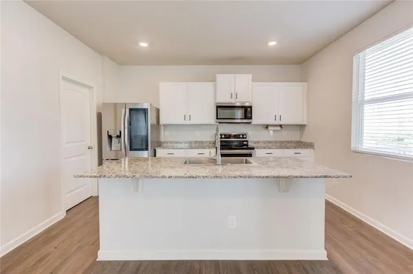 a kitchen with stainless steel appliances granite countertop a sink stove and refrigerator