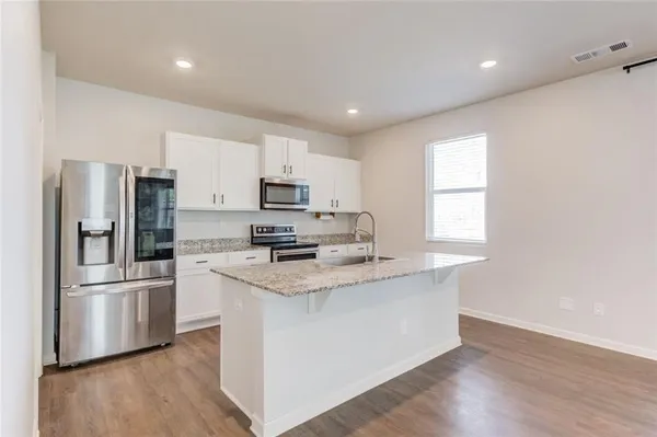 a kitchen with granite countertop a sink and cabinets