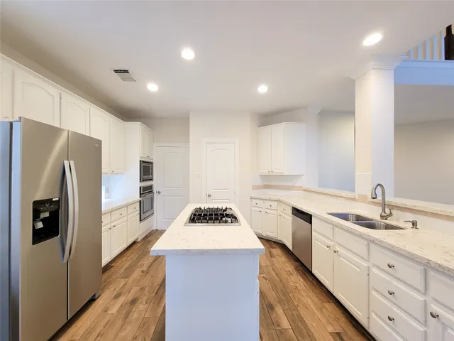 a kitchen with white cabinets and stainless steel appliances